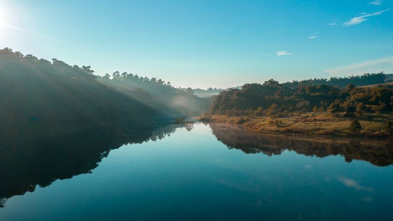 Rio espelhado com neblina pela manhã