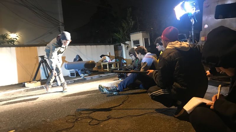 Equipe de som e câmera em gravação noturna na rua